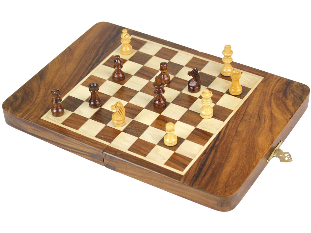 Fully open chess board with pieces on top