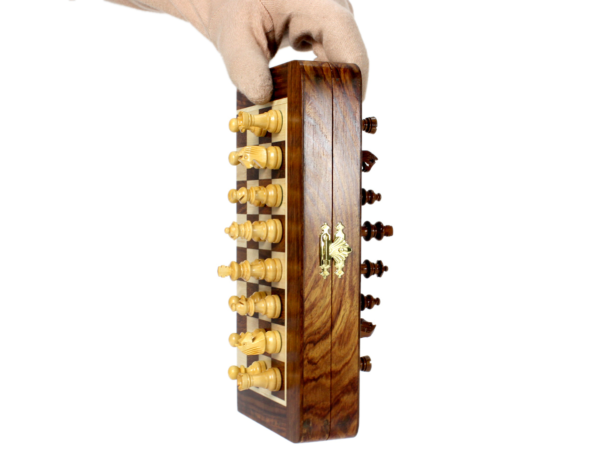 Folding chess board held vertically and magnetic pieces attached to it