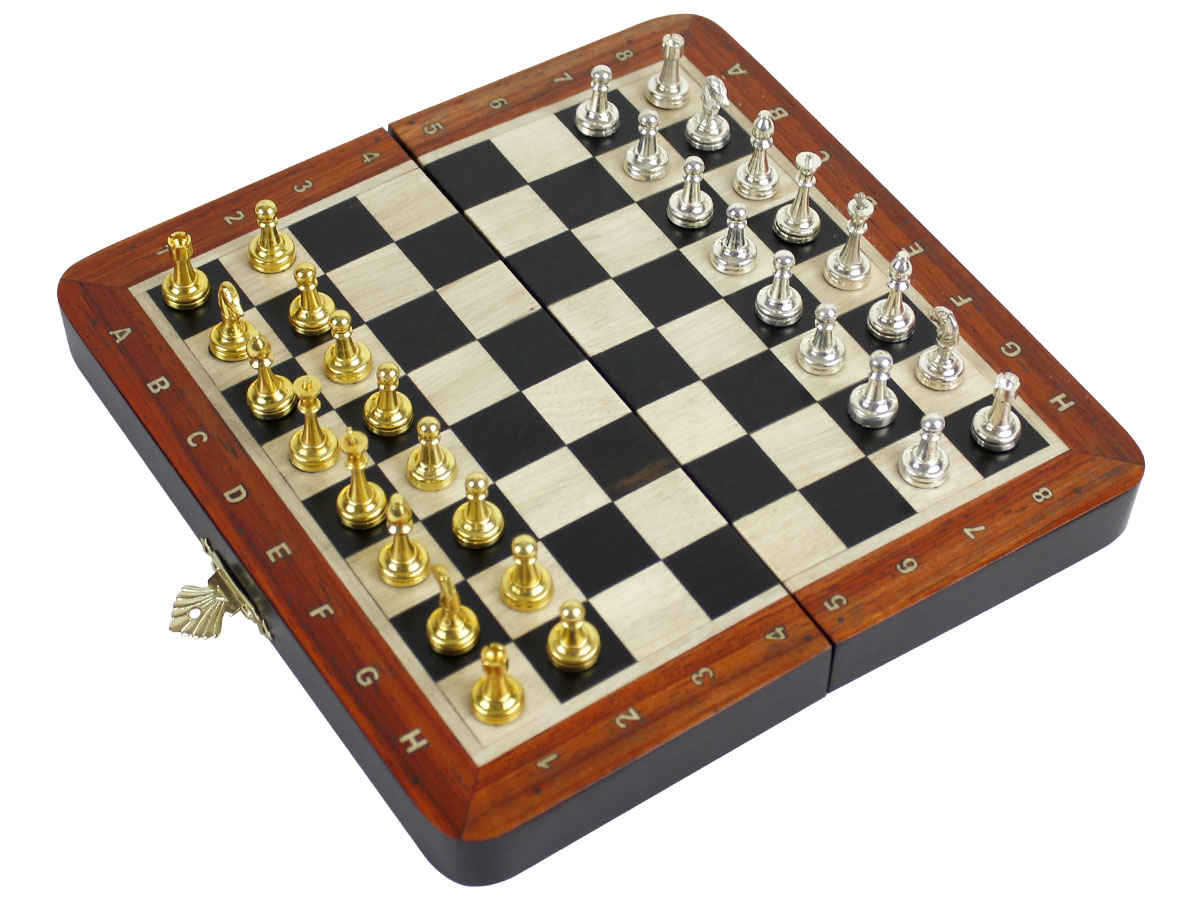 Side view of flat chess board with metal pieces