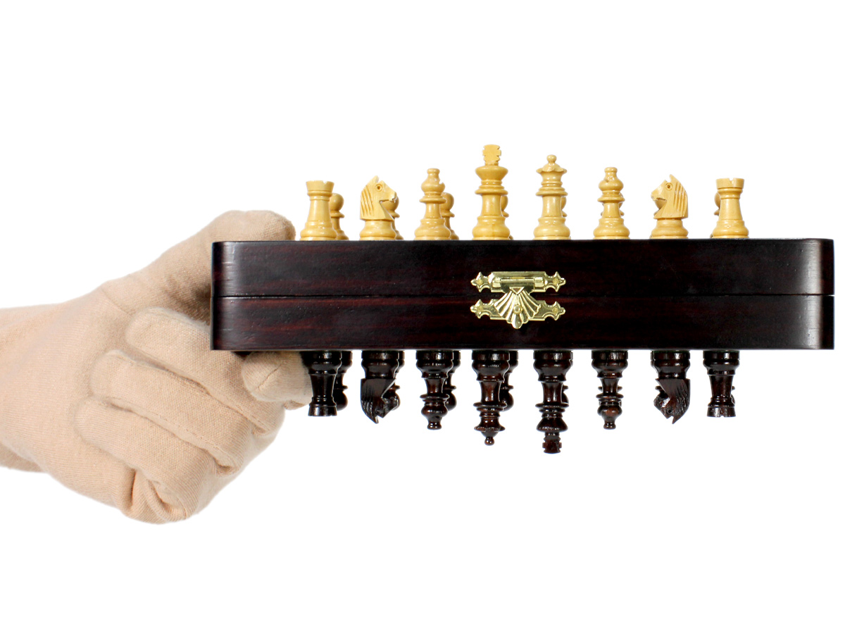 Folding chess board held upside down and magnetic pieces attached to it